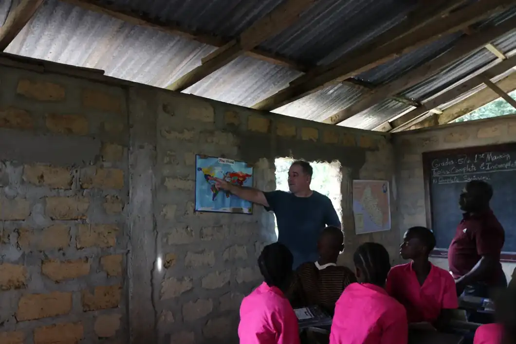 A visitor pointing to a map inside a classroom