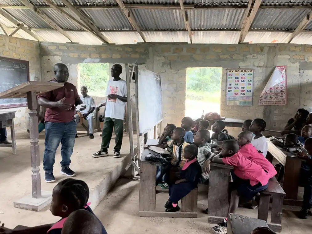 Students listen to a community educator inside a classroom
